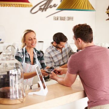 Young man paying for his order in a cafe